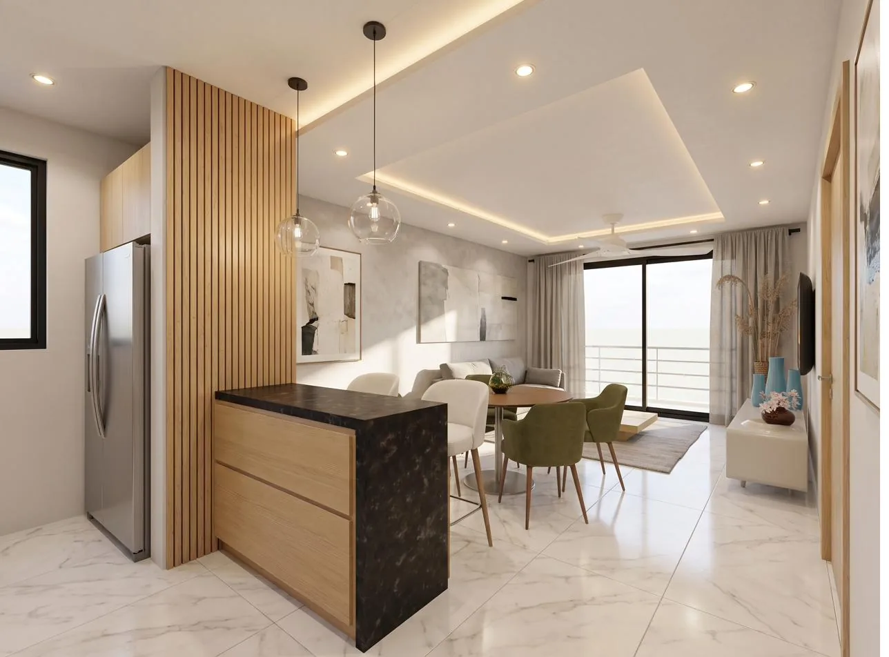 Cocina abierta con barra y sala comedor hacia el balcón