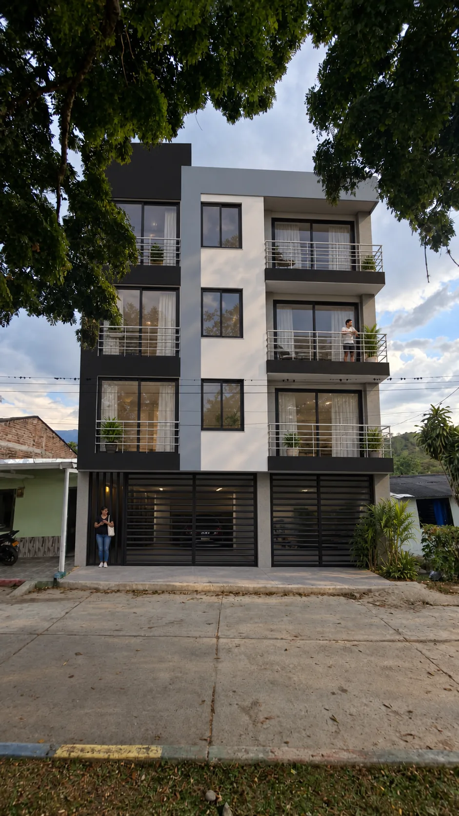 Fachada del Edificio La Magdalena sobre la calle, bajo los árboles del parque principal de la vereda